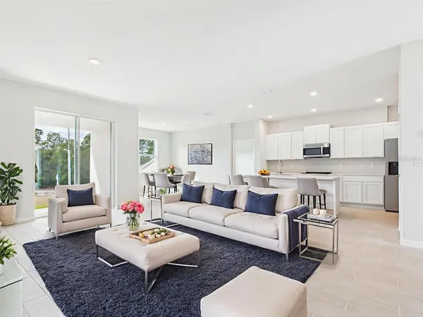 a living room with furniture and a view of kitchen