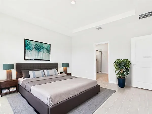 a bedroom with a large bed and a potted plant