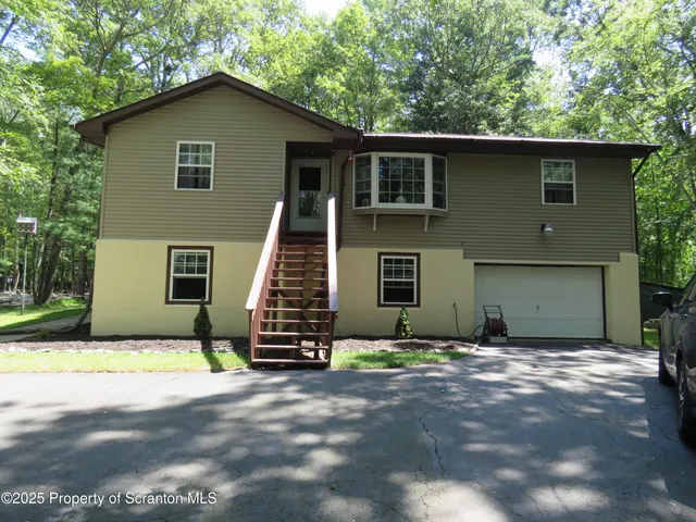 a view of a house with backyard and trees