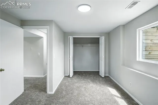 an empty room with windows and closet