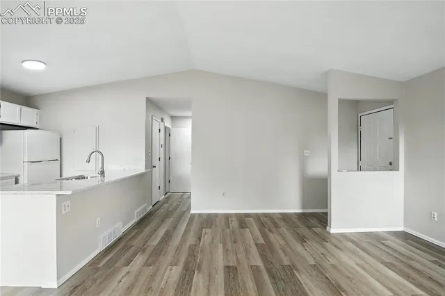 a view of a kitchen with wooden floor and a sink