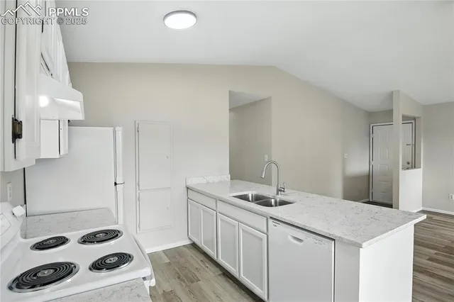 a kitchen with a sink a stove and white cabinets