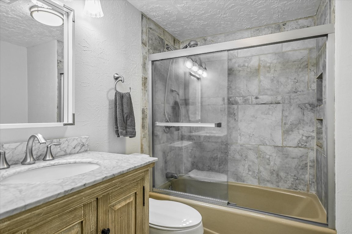 175 Fischer Trail Wimberley, TX 78676 - Photo 16 of 33 a bathroom with a granite countertop sink toilet and shower
