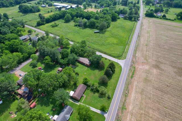 a view of a lush green hillside and a houses with view