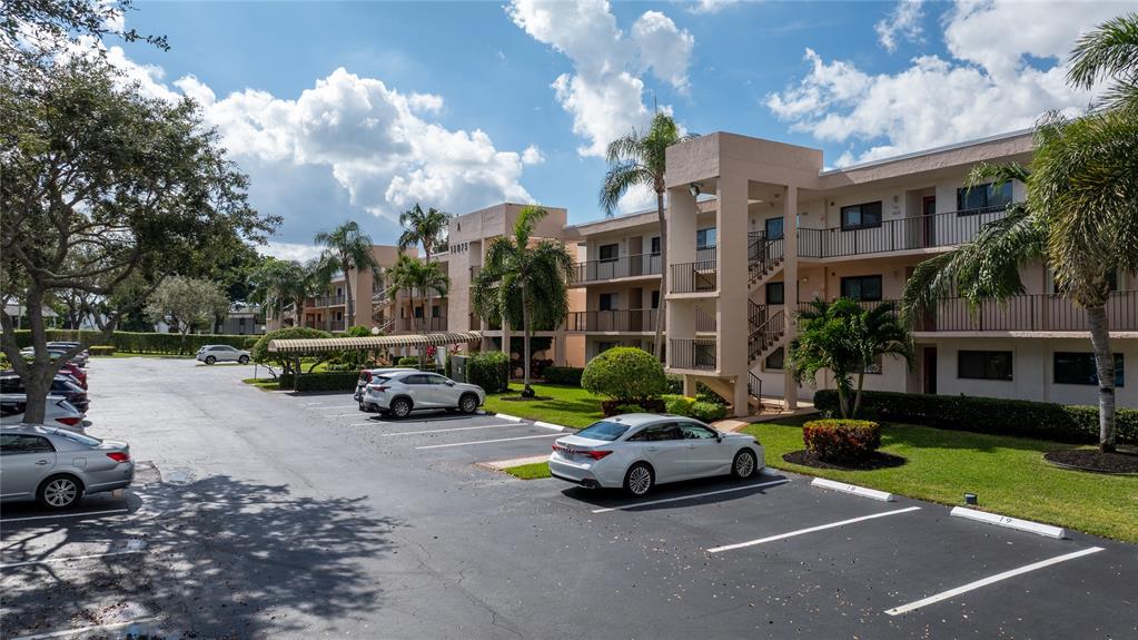 15075 Witney Road, Unit A303 Delray Beach, FL 33484 - Photo 18 of 26 a car parked in front of a brick house