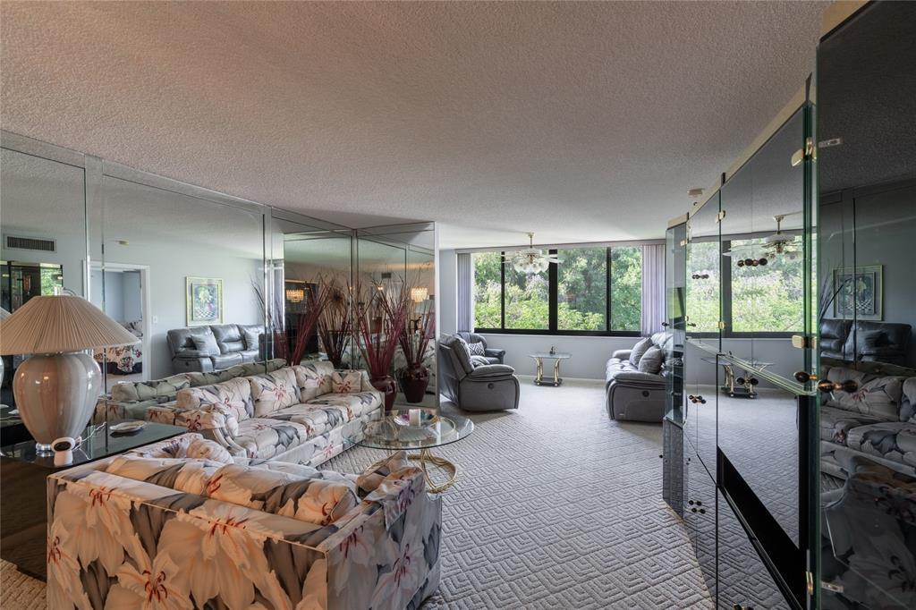 15075 Witney Road, Unit A303 Delray Beach, FL 33484 - Photo 5 of 26 a living room with furniture fireplace and large windows