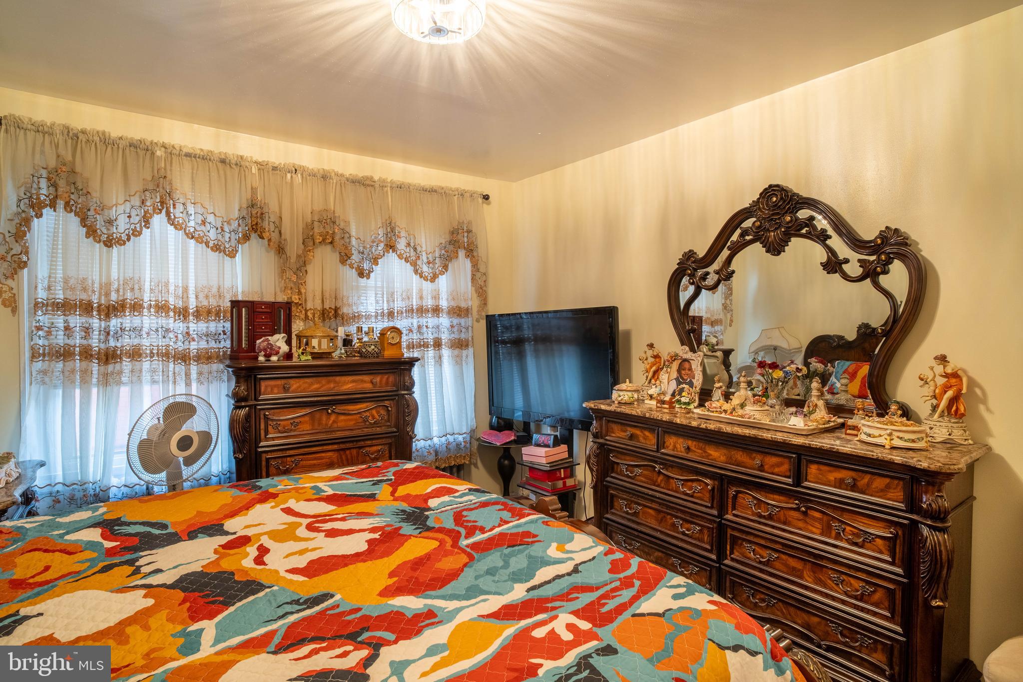 1227 Harrison Street Philadelphia, PA 19124 - Photo 14 of 38 a bedroom with a bed and a chandelier