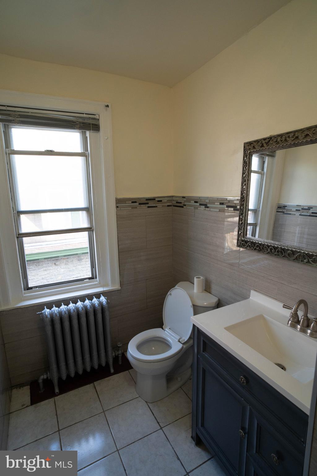 1227 Harrison Street Philadelphia, PA 19124 - Photo 19 of 38 a bathroom with a sink toilet and mirror
