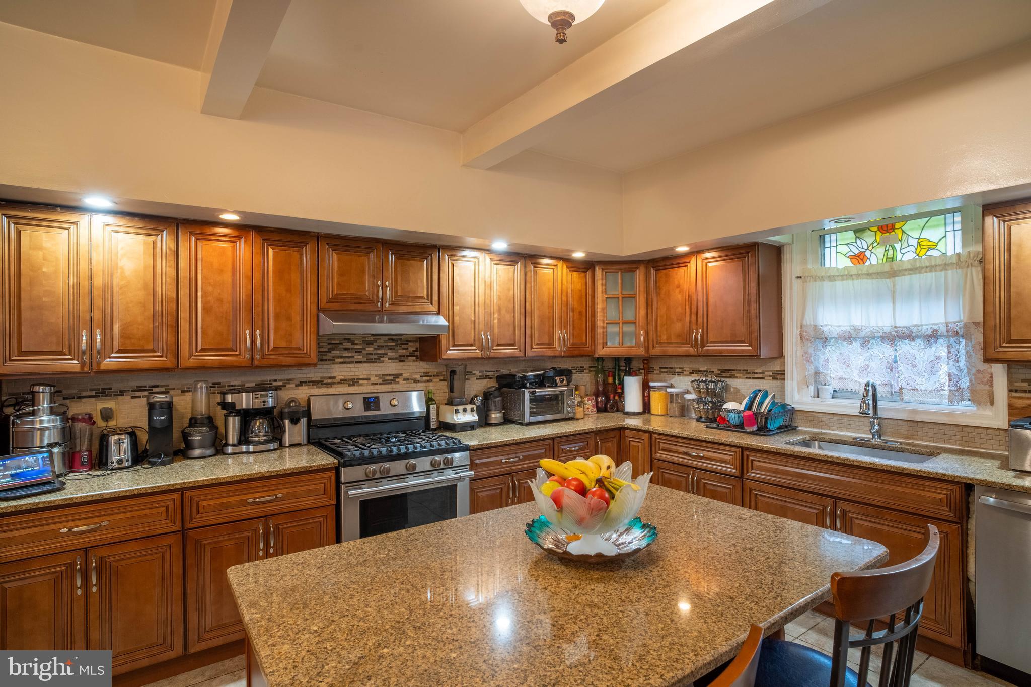 1227 Harrison Street Philadelphia, PA 19124 - Photo 25 of 38 a kitchen with a stove a sink dishwasher a dining table and chairs with wooden floor