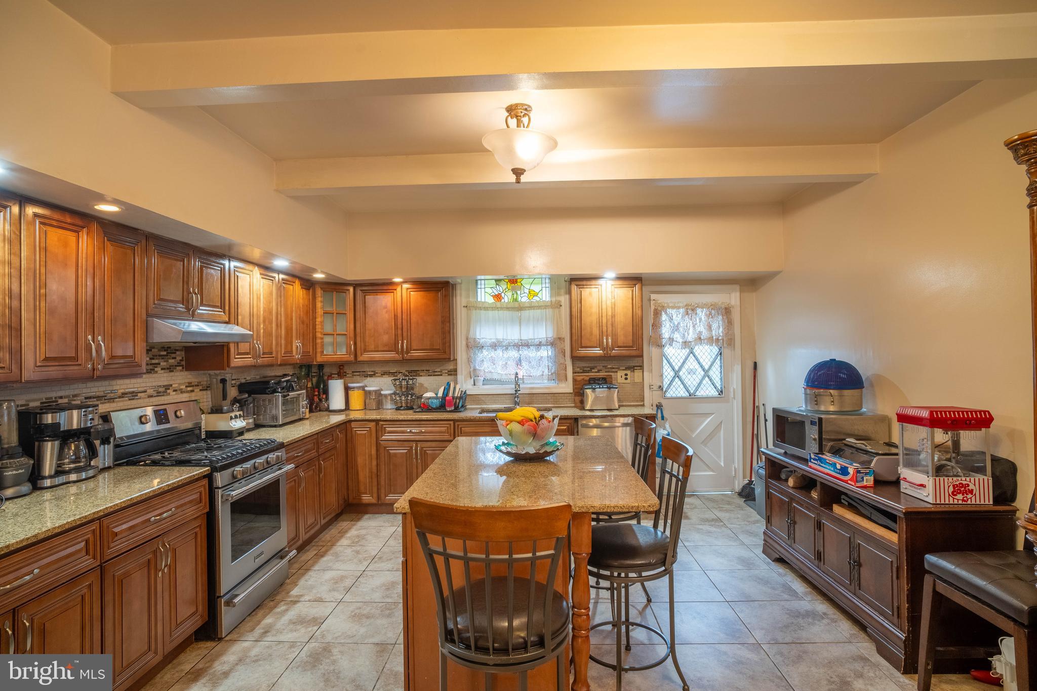 1227 Harrison Street Philadelphia, PA 19124 - Photo 9 of 38 a kitchen with stainless steel appliances a stove a sink dishwasher and cabinets with wooden floor