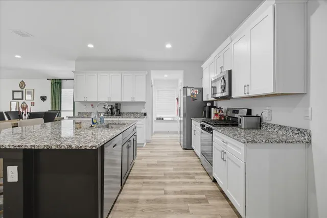 a kitchen with stainless steel appliances granite countertop a sink stove and cabinets