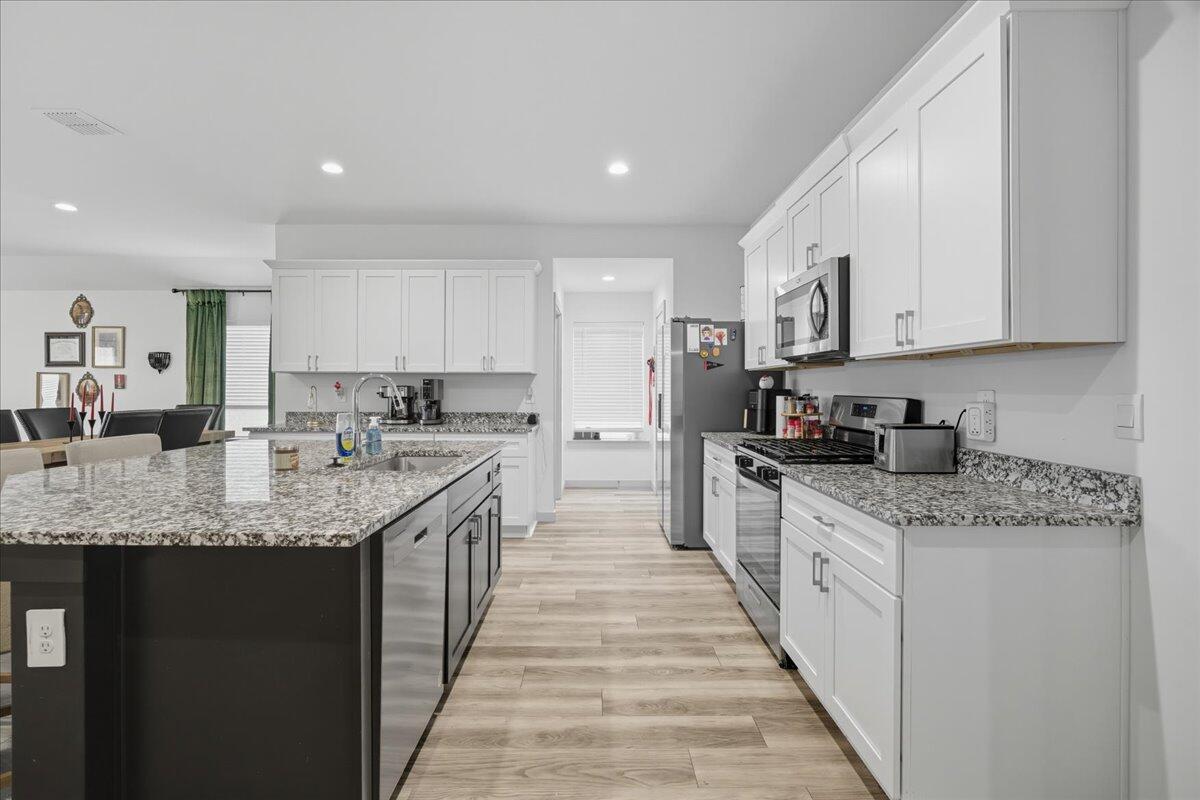 2309 149th Street Lubbock, TX 79423 - Photo 21 of 31 a kitchen with stainless steel appliances granite countertop a sink stove and cabinets