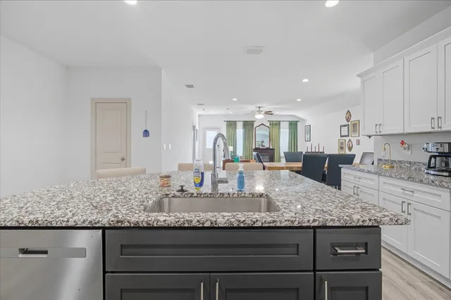 a kitchen with granite countertop kitchen island a sink appliances and cabinets