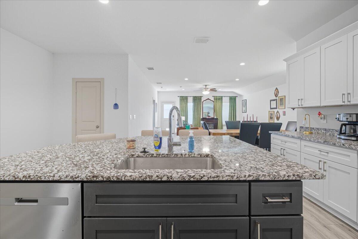 2309 149th Street Lubbock, TX 79423 - Photo 24 of 31 a kitchen with granite countertop kitchen island a sink appliances and cabinets