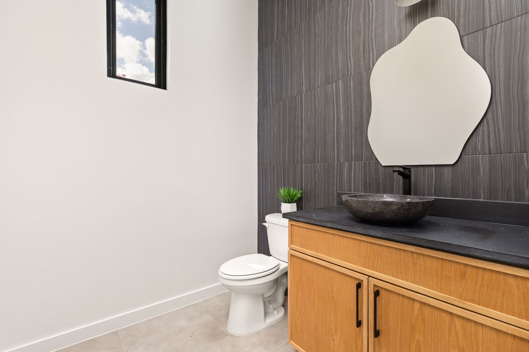2717 Lyons Road, Unit 1 Austin, TX 78702 - Photo 13 of 40 Modern bathroom featuring a stylish vessel sink and a striking dark tile accent wall.