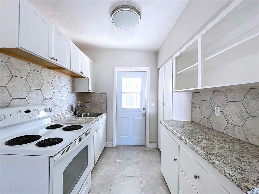 501 Spring Avenue Anna Maria, FL 34216 - Photo 14 of 49 a kitchen with a sink stove and cabinets