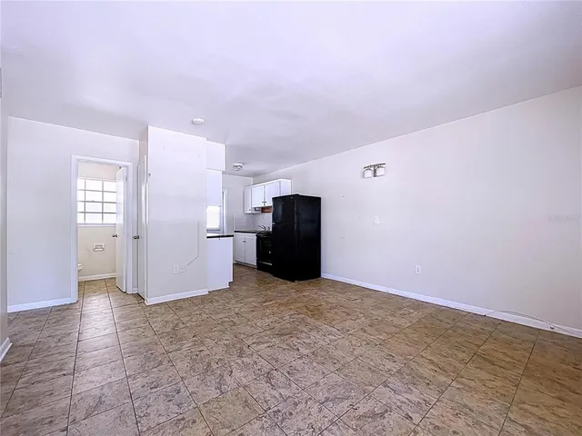 a view of kitchen with refrigerator cabinets and wooden floor