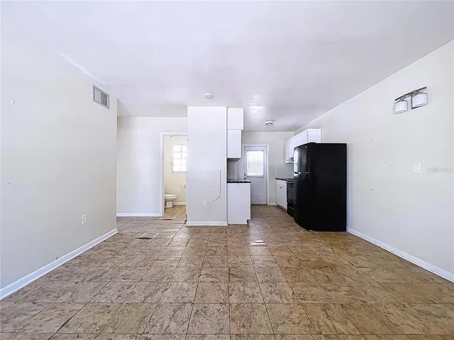 a kitchen with granite countertop a sink a stove and refrigerator