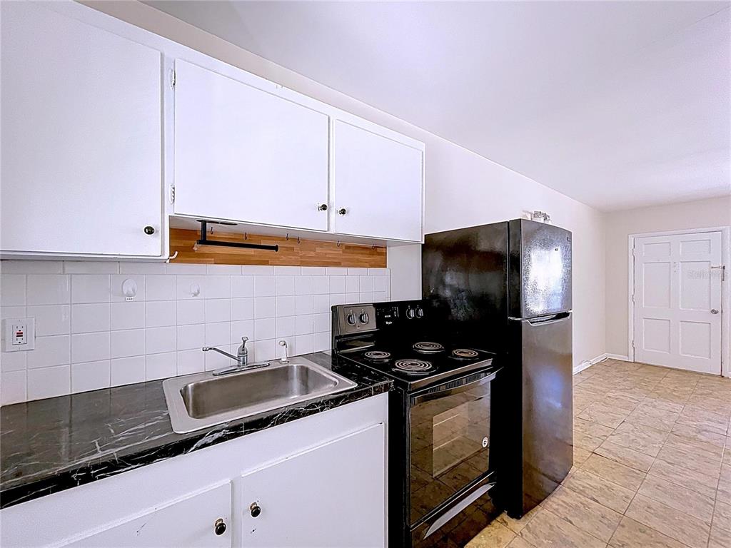 501 Spring Avenue Anna Maria, FL 34216 - Photo 30 of 49 a kitchen with granite countertop a sink a stove and refrigerator