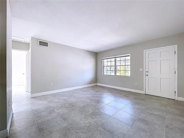 a view of a kitchen with refrigerator and white cabinets