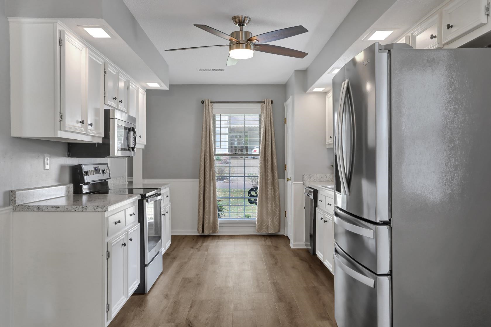 372 Dove Valley Road Collierville, TN 38017 - Photo 12 of 32 a kitchen with stainless steel appliances granite countertop a refrigerator a stove a sink and dishwasher with wooden floor