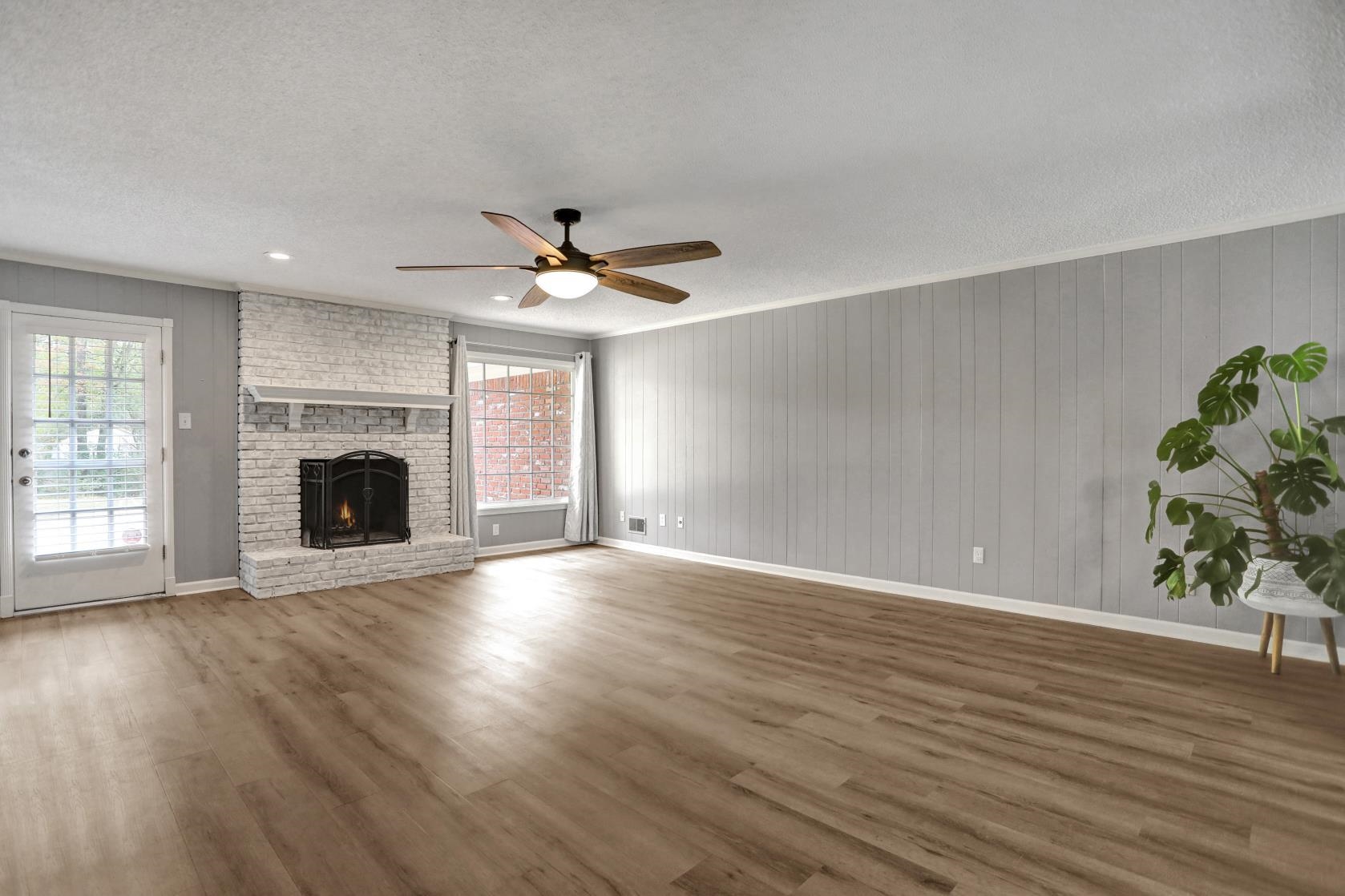 372 Dove Valley Road Collierville, TN 38017 - Photo 6 of 32 an empty room with wooden floor a fireplace and windows