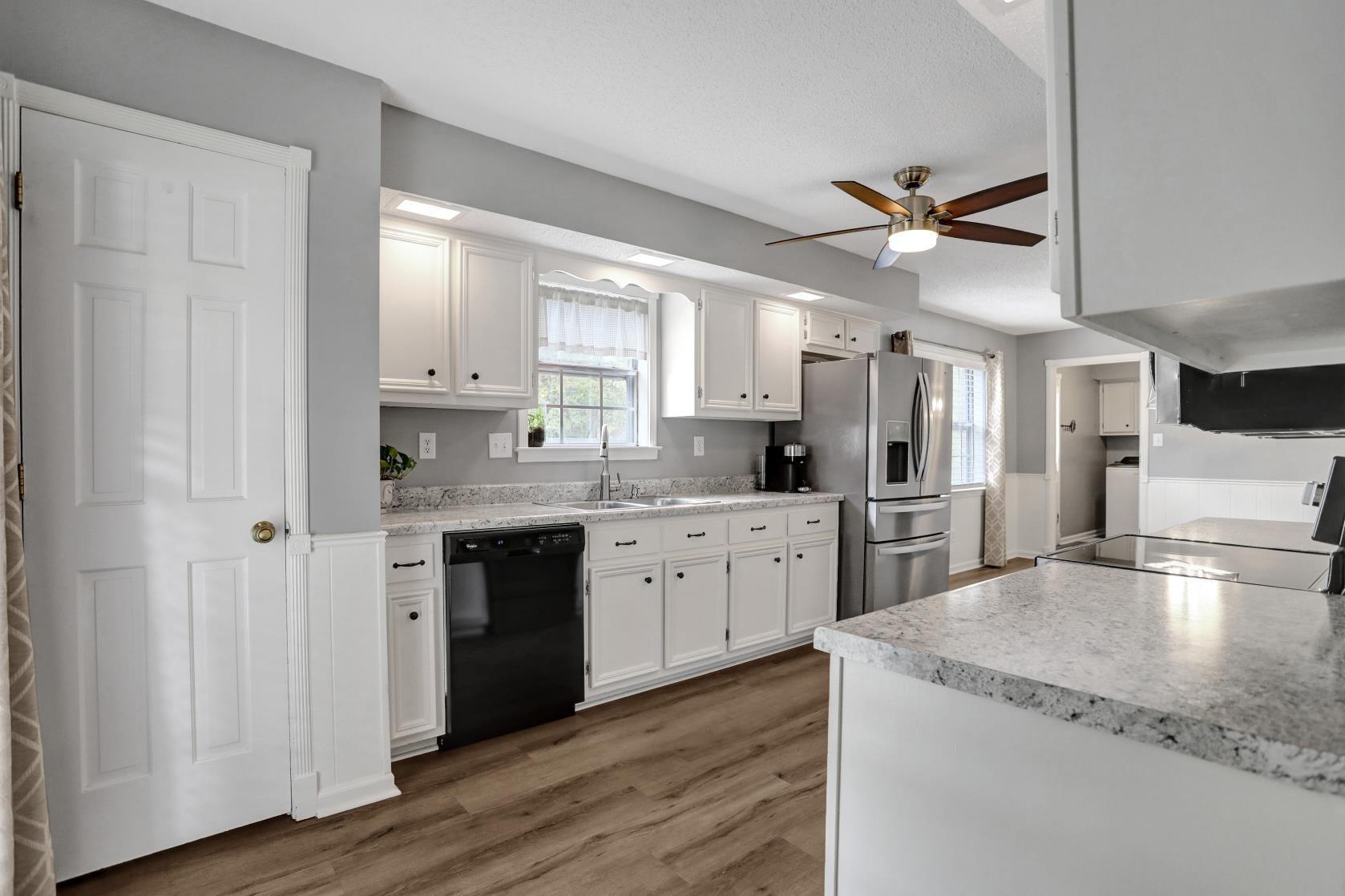 372 Dove Valley Road Collierville, TN 38017 - Photo 10 of 32 a kitchen with stainless steel appliances granite countertop a refrigerator a sink dishwasher a stove and white countertops with wooden floor