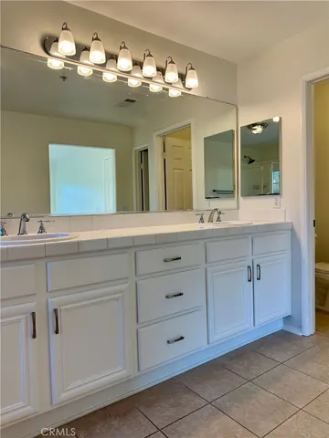 a bathroom with a double vanity sink and a mirror