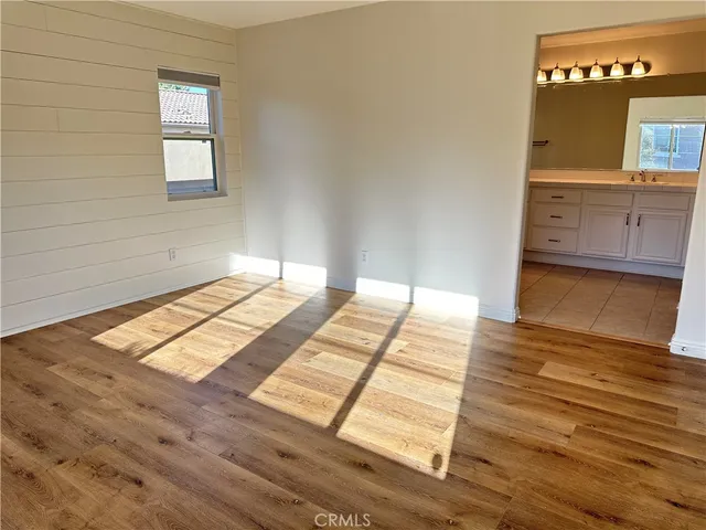 a view of a bedroom with wooden floor and window