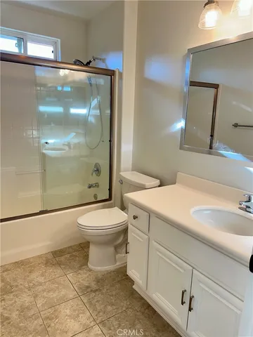 a bathroom with a toilet sink vanity and shower