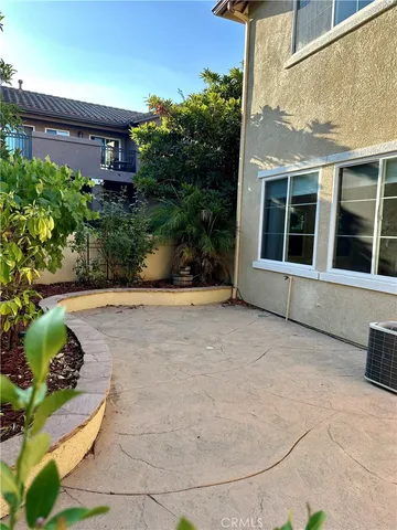 a view of a house with a yard and potted plants