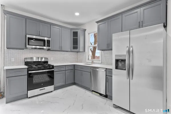 a kitchen with stainless steel appliances granite countertop a refrigerator stove a sink and microwave