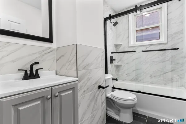 a bathroom with a sink a toilet and shower