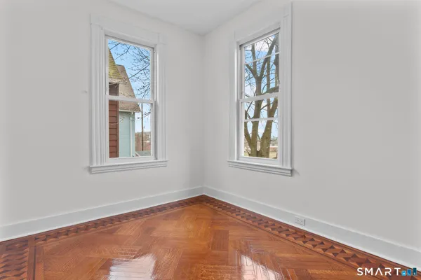 a view of an empty room with a window and closet area