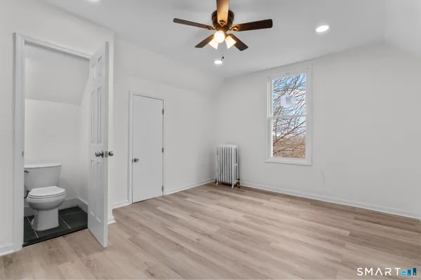 a view of a room with a hardwood and a ceiling fan