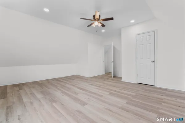 wooden floor in an empty room with a ceiling fan