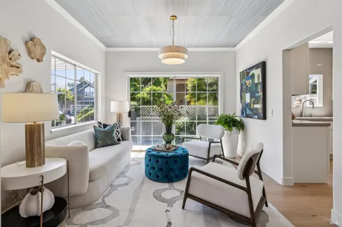 a living room with furniture a fireplace and a floor to ceiling window