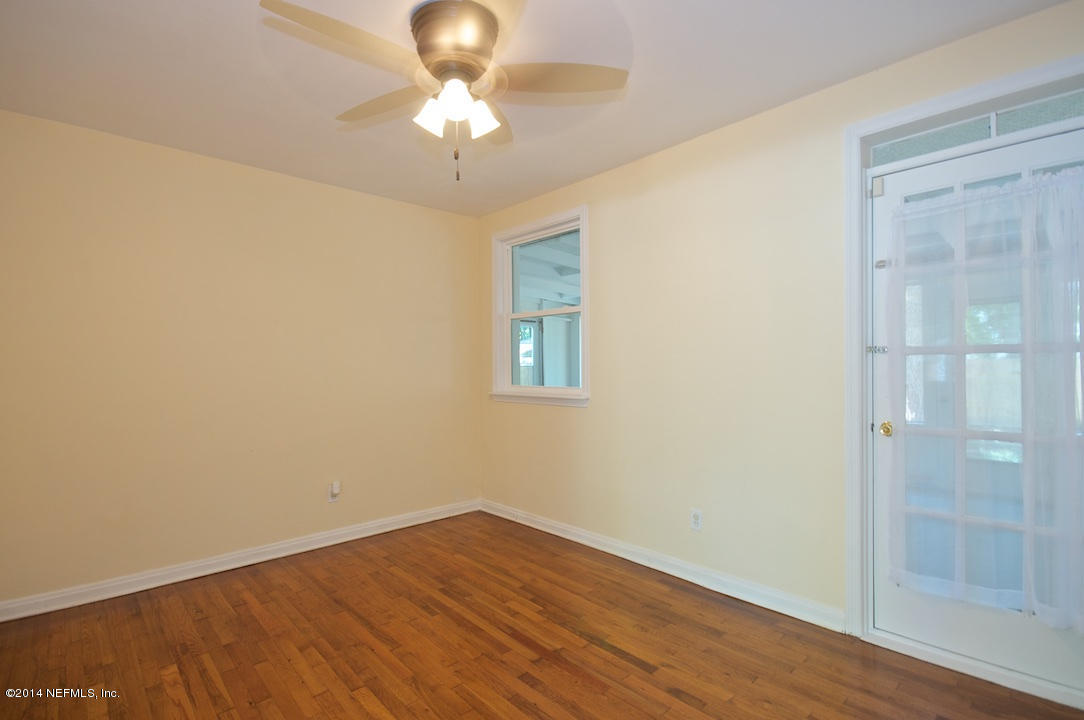 5614 Stetson Road Jacksonville, FL 32207 - Photo 10 of 20 an empty room with wooden floor and chandelier fan