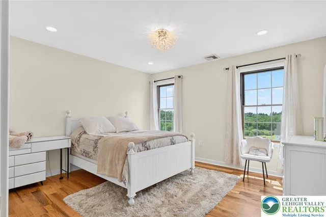 a view of swimming pool with lawn chairs plants and swimming pool