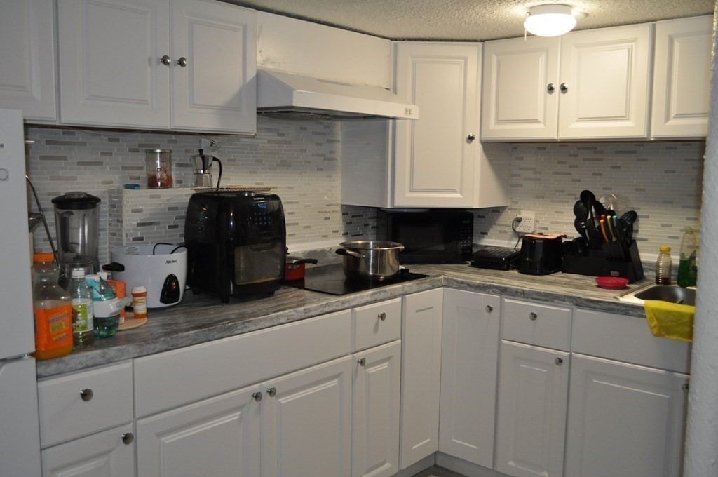 111 Wilber Street Springfield, MA 01104 - Photo 19 of 26 a kitchen with white cabinets and appliances