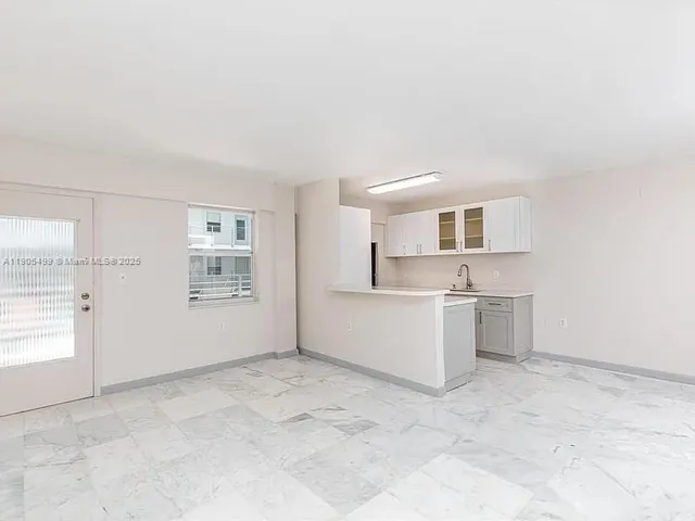 a view of a kitchen with a sink and a refrigerator