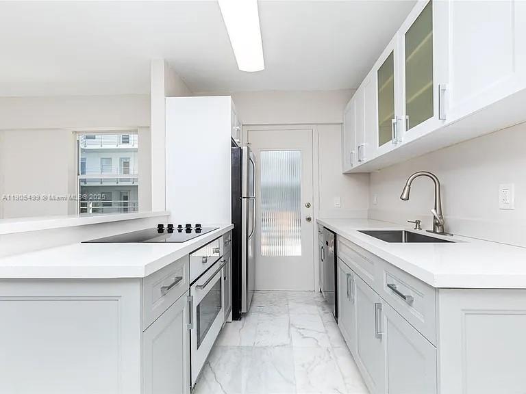 1545 Euclid Avenue, Unit 2D Miami Beach, FL 33139 - Photo 13 of 23 a kitchen with a sink stove and refrigerator