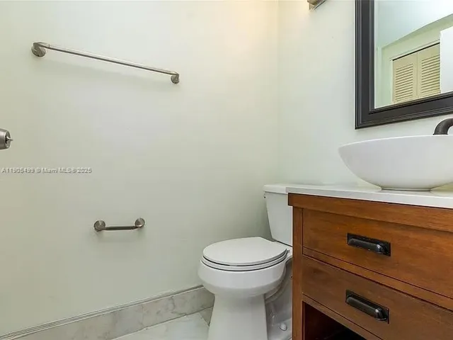 a bathroom with a granite countertop toilet and a sink