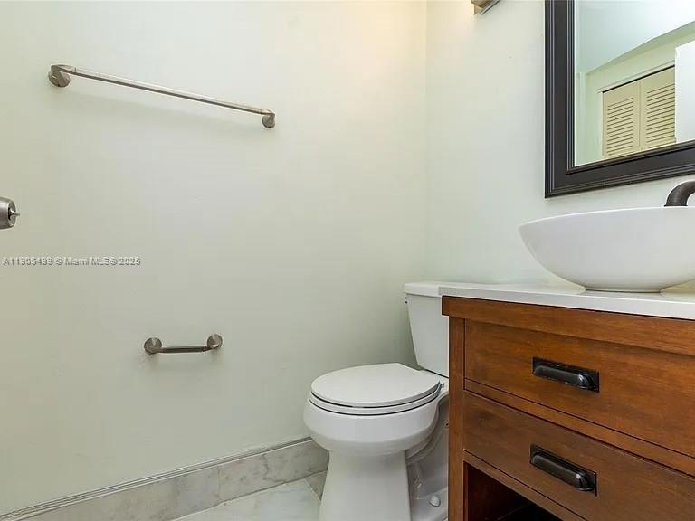 1545 Euclid Avenue, Unit 2D Miami Beach, FL 33139 - Photo 23 of 23 a bathroom with a granite countertop toilet and a sink