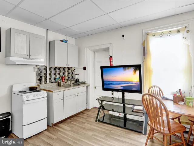 a kitchen with stainless steel appliances white cabinets and wooden floor