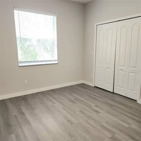 a view of a livingroom with wooden floor and a window