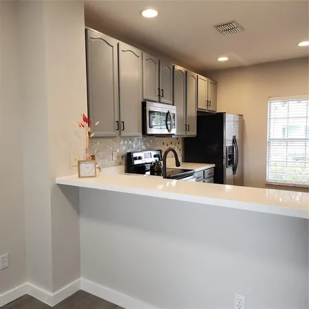 a kitchen with stainless steel appliances a refrigerator sink and microwave