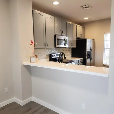 a kitchen with a sink a stove and cabinets