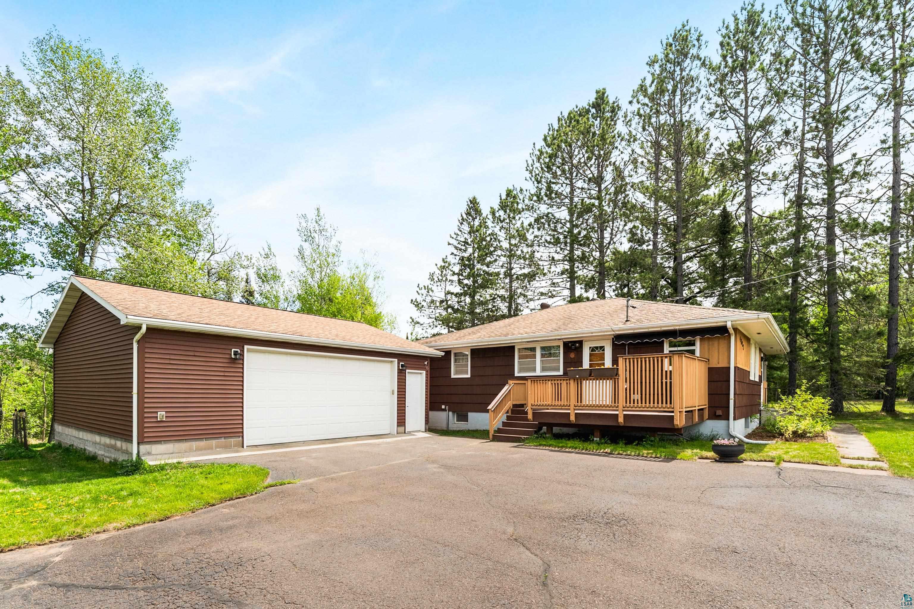 4808 Midway Road Duluth, MN 55811 - Photo 2 of 57 Property exterior featuring brown siding, a light brown shingle roof, and a wooden deck with railing