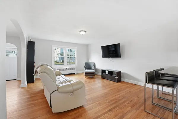 a living room with furniture a table and kitchen view